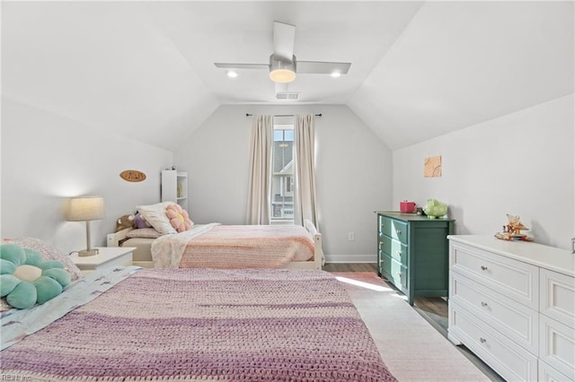 bedroom featuring visible vents, ceiling fan, vaulted ceiling, wood finished floors, and baseboards