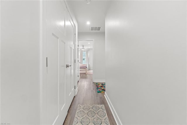 corridor featuring recessed lighting, wood finished floors, visible vents, and baseboards