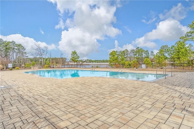 community pool with a patio and fence