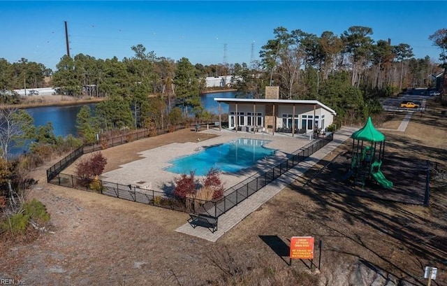 view of pool featuring a fenced in pool, a patio, playground community, a water view, and fence