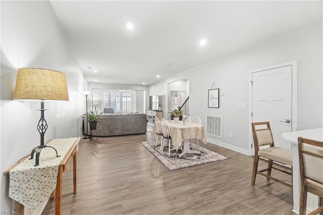 dining room featuring baseboards, wood finished floors, visible vents, and recessed lighting