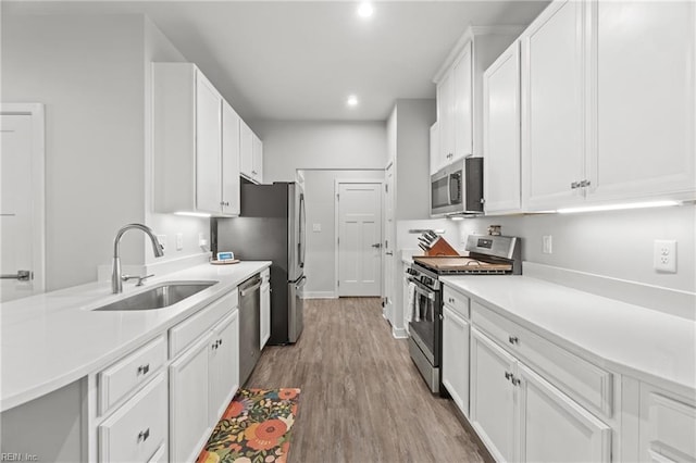 kitchen with stainless steel appliances, white cabinets, and a sink