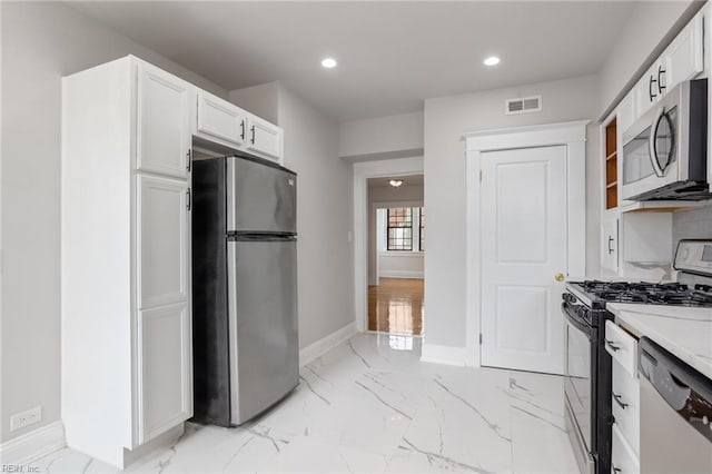 kitchen featuring marble finish floor, visible vents, appliances with stainless steel finishes, white cabinetry, and baseboards