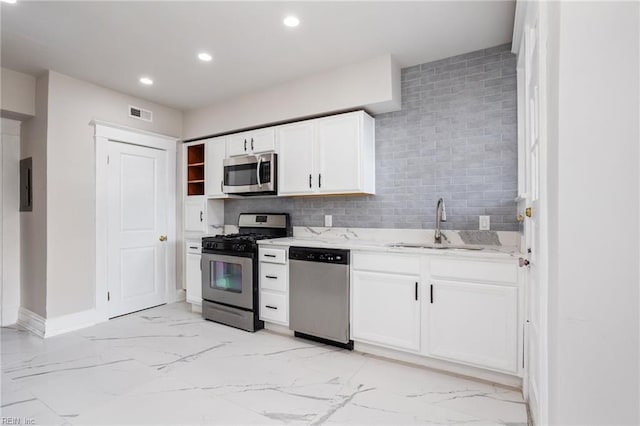 kitchen featuring recessed lighting, stainless steel appliances, white cabinetry, marble finish floor, and electric panel