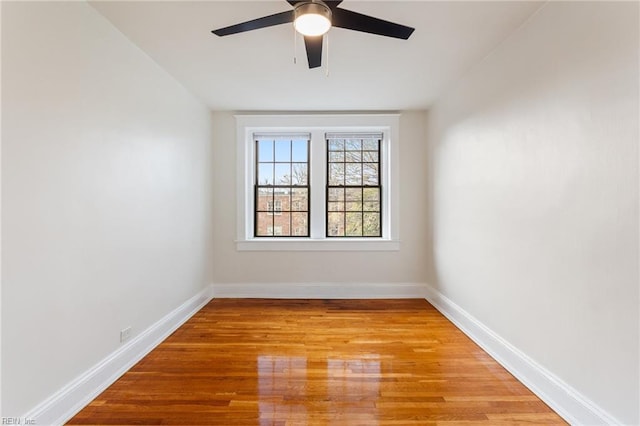 unfurnished room with ceiling fan, light wood-style flooring, and baseboards