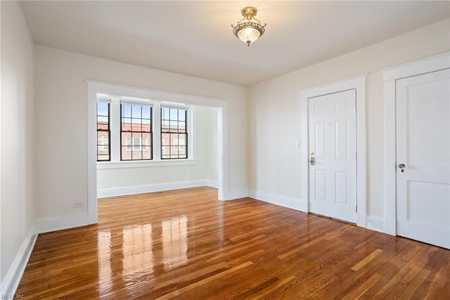 unfurnished room with baseboards and wood finished floors