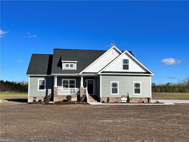 view of front of property with crawl space, a porch, board and batten siding, and roof with shingles