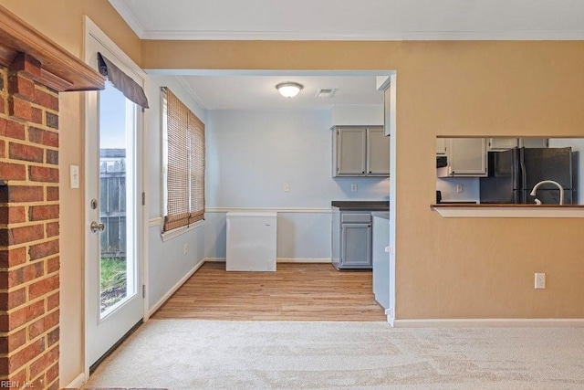 kitchen featuring light colored carpet, gray cabinets, crown molding, and freestanding refrigerator