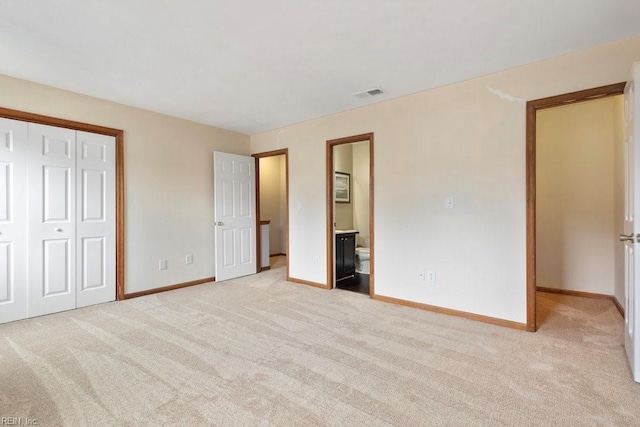 unfurnished bedroom featuring light colored carpet, a closet, visible vents, and baseboards