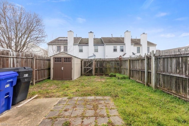 view of yard with a fenced backyard, a storage unit, a patio, and an outdoor structure