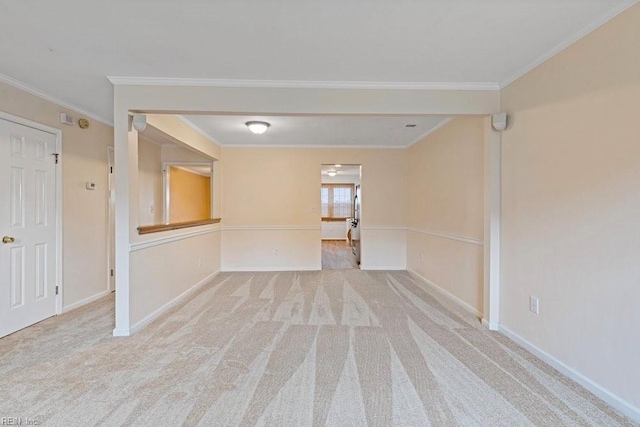 empty room featuring baseboards, carpet flooring, and crown molding