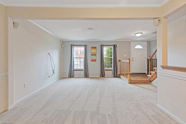 foyer entrance featuring baseboards, visible vents, crown molding, and light colored carpet