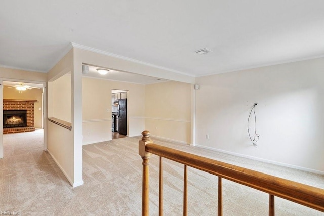 hallway with baseboards, light carpet, crown molding, and an upstairs landing