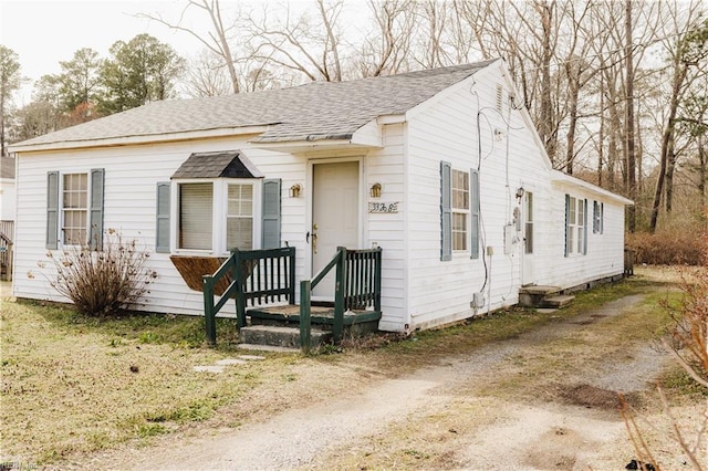 view of front of property with driveway and roof with shingles