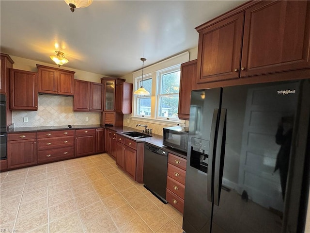 kitchen featuring dark countertops, black appliances, backsplash, and a sink