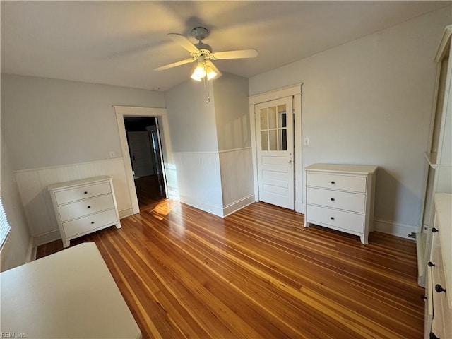 unfurnished bedroom with wainscoting, ceiling fan, and wood finished floors