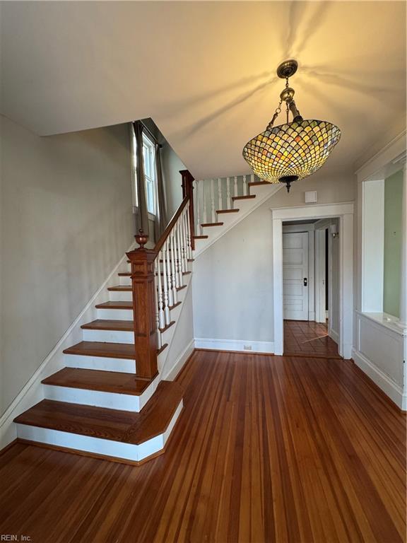 stairway with baseboards and wood finished floors