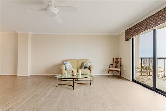 sitting room with crown molding, baseboards, ceiling fan, and wood finished floors