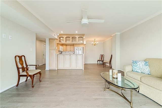 living area featuring recessed lighting, light wood-style flooring, ornamental molding, baseboards, and ceiling fan with notable chandelier