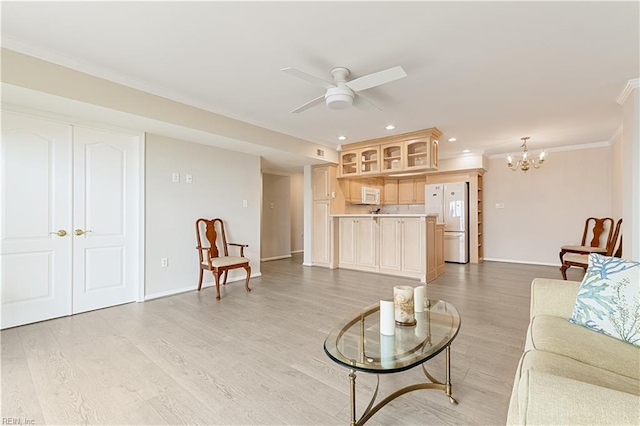 living area with ceiling fan with notable chandelier, light wood finished floors, recessed lighting, and crown molding