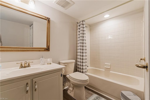 full bathroom featuring toilet, wood finished floors, vanity, visible vents, and shower / bath combination with curtain