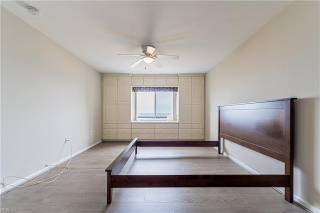 interior space featuring baseboards, a ceiling fan, and light wood-style floors