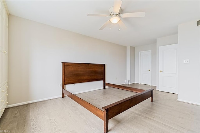 unfurnished bedroom featuring visible vents, ceiling fan, baseboards, and wood finished floors