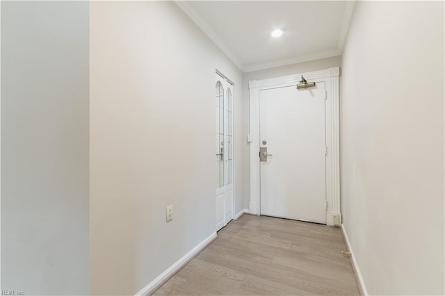 doorway with light wood-style floors, crown molding, and baseboards