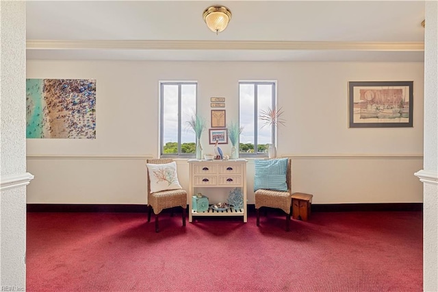 sitting room with baseboards, carpet floors, crown molding, and ornate columns