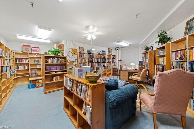 sitting room with carpet floors and bookshelves