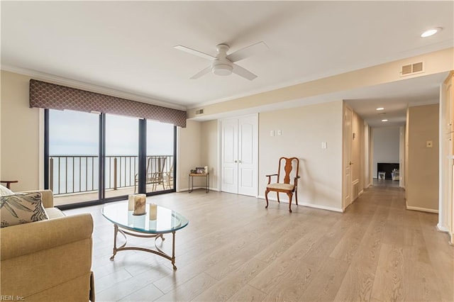 living area with light wood-style floors, visible vents, ornamental molding, and baseboards