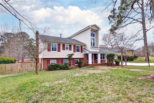 tri-level home with a chimney, fence, a front lawn, and brick siding