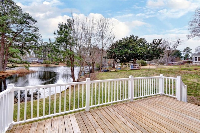 deck with a water view and a lawn