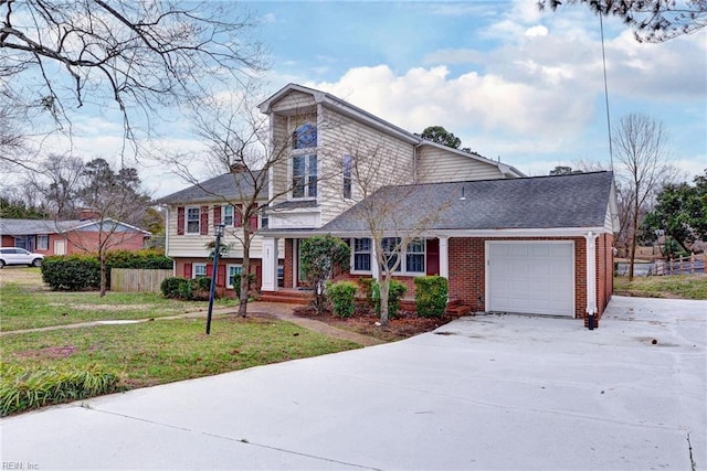 split level home featuring an attached garage, a front yard, fence, and brick siding