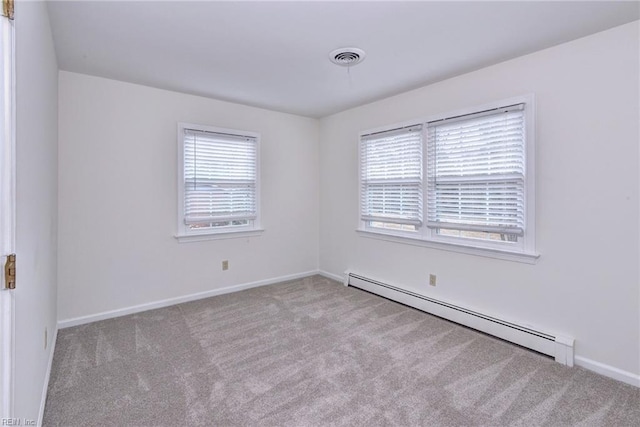 carpeted empty room featuring a wealth of natural light, baseboards, visible vents, and baseboard heating