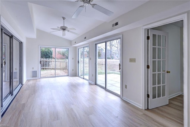 unfurnished room with lofted ceiling, light wood-style floors, baseboards, and visible vents