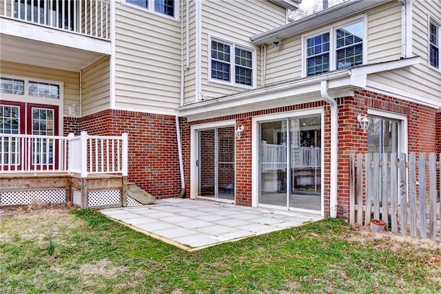 entrance to property with a patio area and brick siding