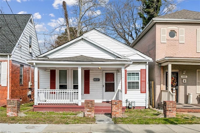 bungalow-style home featuring a shingled roof and covered porch