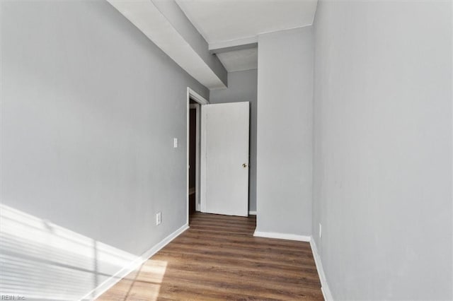 unfurnished room with baseboards and wood finished floors