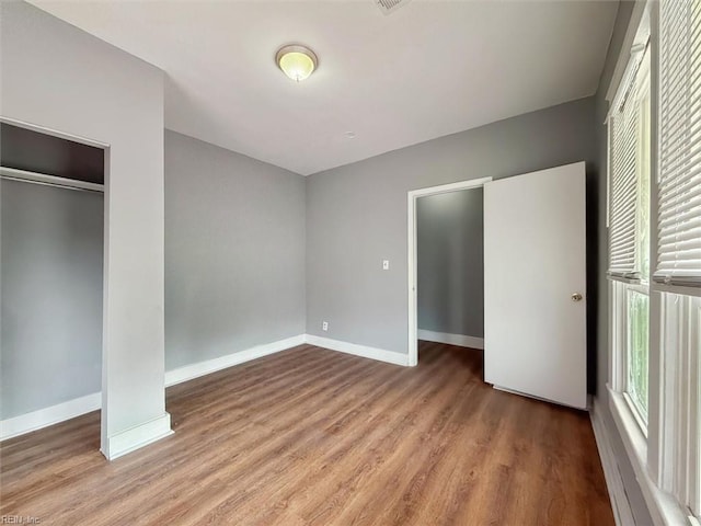 unfurnished bedroom with wood finished floors and baseboards