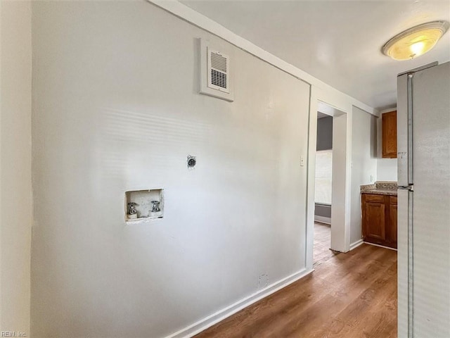 interior space with visible vents, baseboards, and wood finished floors