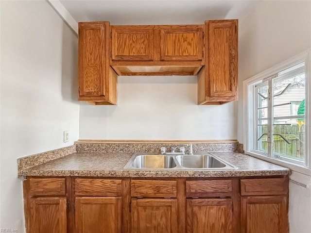 kitchen featuring brown cabinetry and a sink