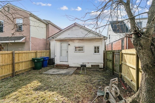 back of house featuring entry steps, central AC, a yard, and a fenced backyard