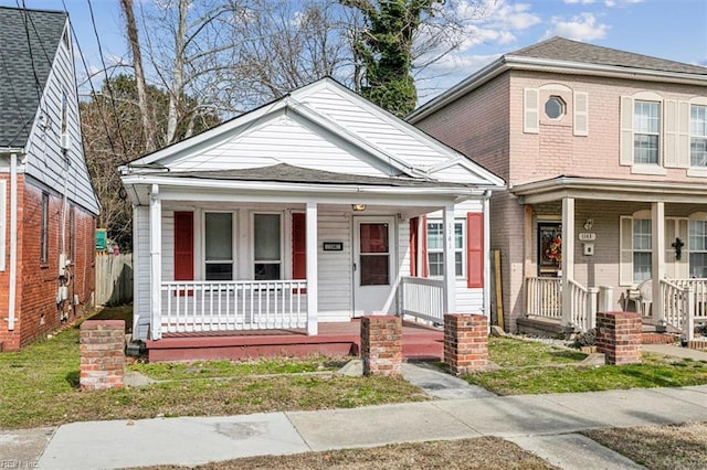 bungalow featuring covered porch and roof with shingles