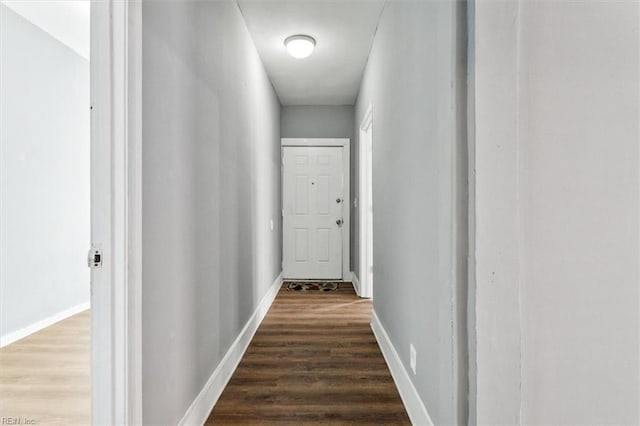 hallway with wood finished floors and baseboards