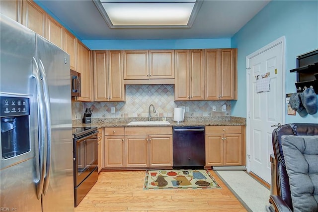 kitchen with stainless steel refrigerator with ice dispenser, black electric range oven, a sink, light stone countertops, and dishwasher