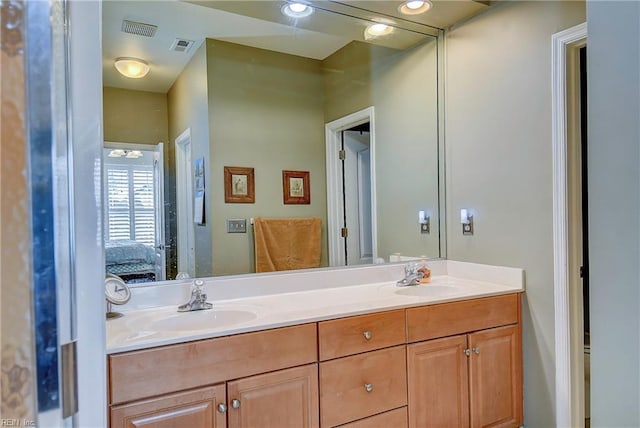 ensuite bathroom featuring connected bathroom, visible vents, a sink, and double vanity