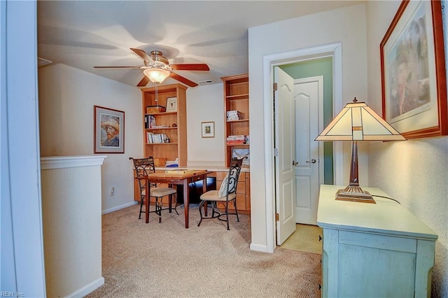 office featuring ceiling fan, baseboards, and light colored carpet