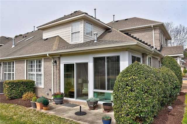 back of house with a patio, brick siding, and roof with shingles