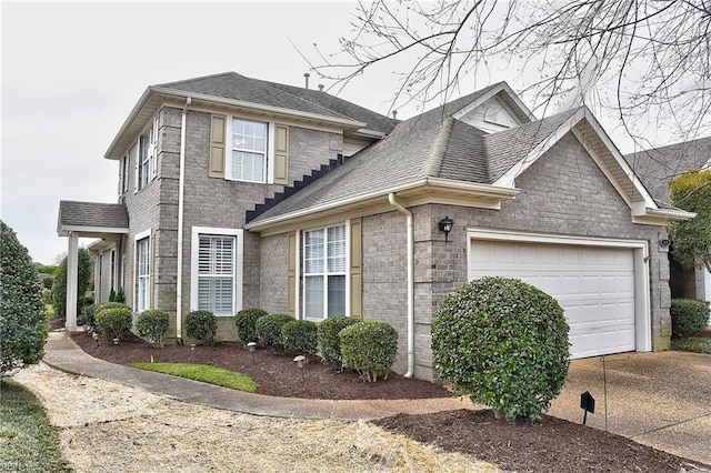 view of front facade with a shingled roof, concrete driveway, brick siding, and an attached garage